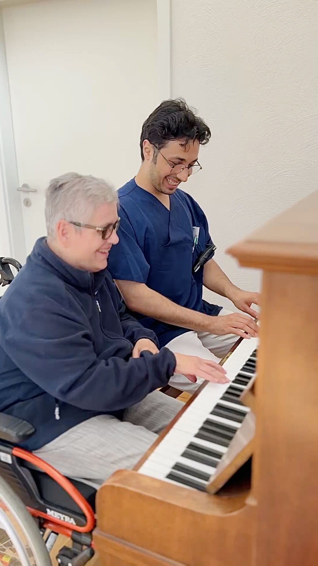 eine Frau und ein Mann sitzen am Klavier und spielen gemeinsam ein Lied. Beide Lachen und freuen sich