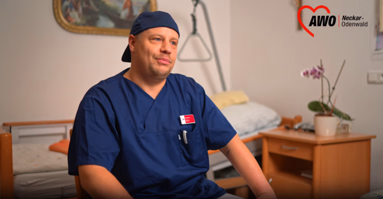 Pflegekraft sitzt vor einem Pflegebett in einem Interview