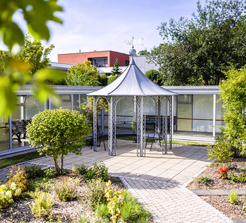 Gartenbereich mit Pavillon und bepflanzten Beeten