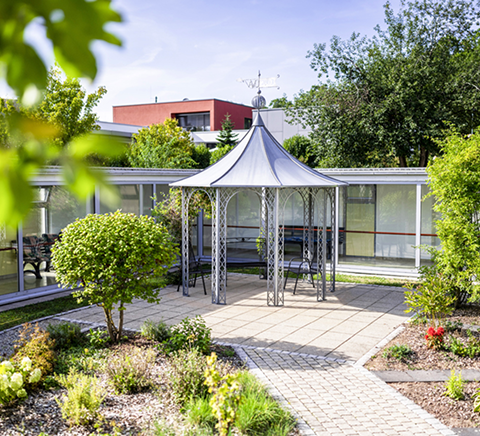 Gartenbereich mit Pavillon und bepflanzten Beeten