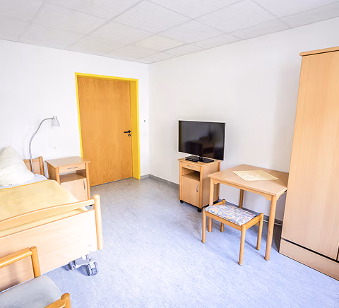 Bewohnerzimmer mit Bett und Tisch