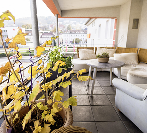Balkon mit Tisch und Sitzmöglichkeiten
