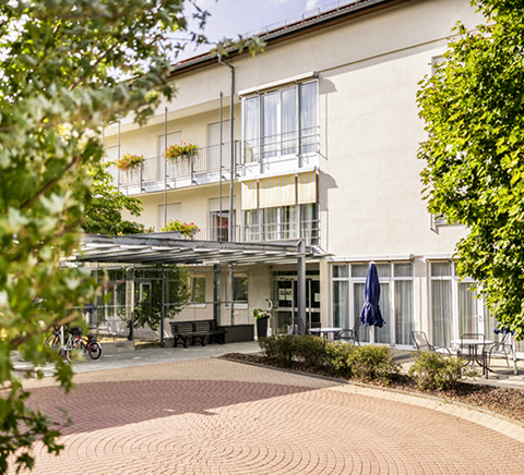 Außenansicht eines mehrstöckigen Gebäudes mit überdachtem Eingangsbereich