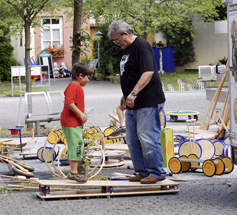 Kinder spielen draußen mit Holzspielzeug auf dem Boden