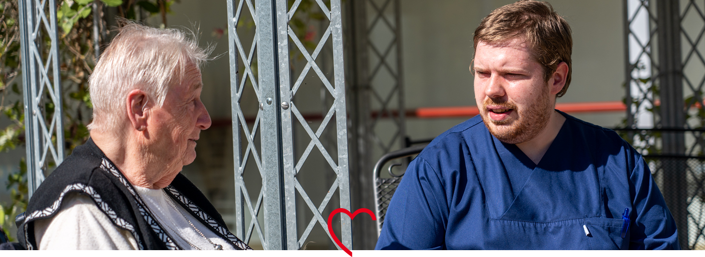 Pflegekraft im Gespräch mit Senior