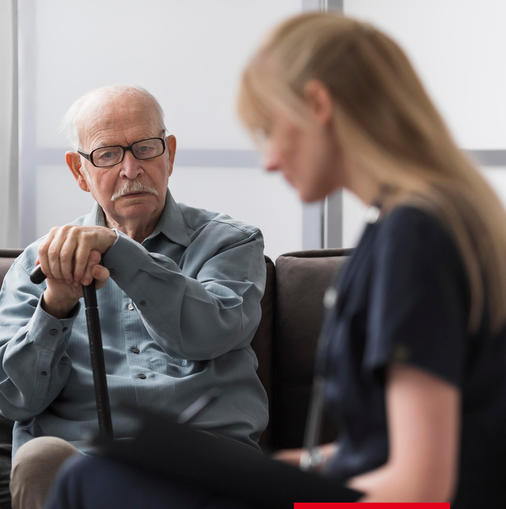 Älterer Mann im Gespräch mit einer Betreuerin