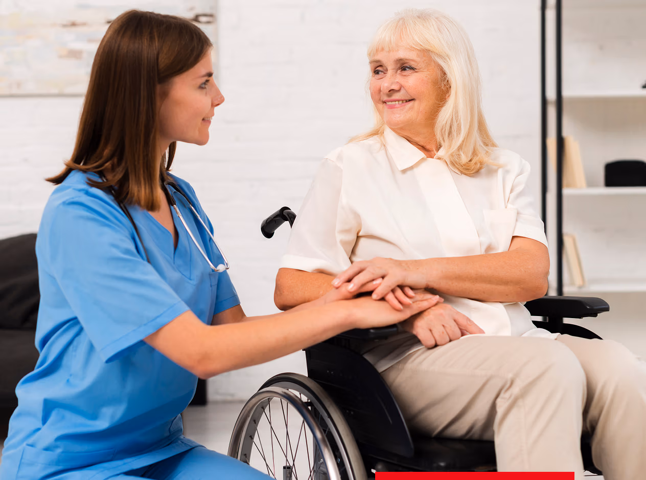 Pflegekraft hilft Seniorin im Rollstuhl