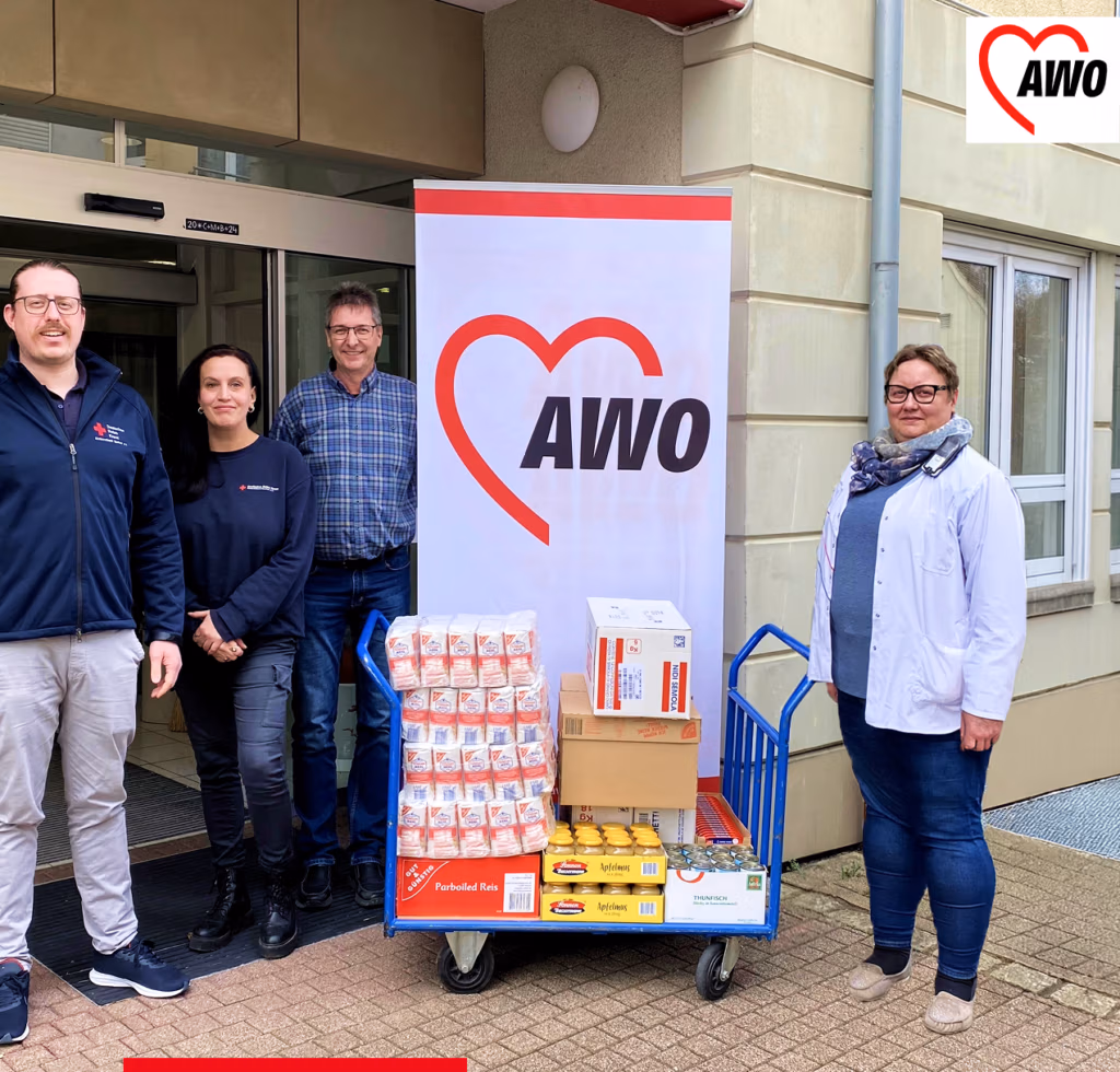 Gruppe von Personen vor einem AWO-Stand mit Lebensmitteln